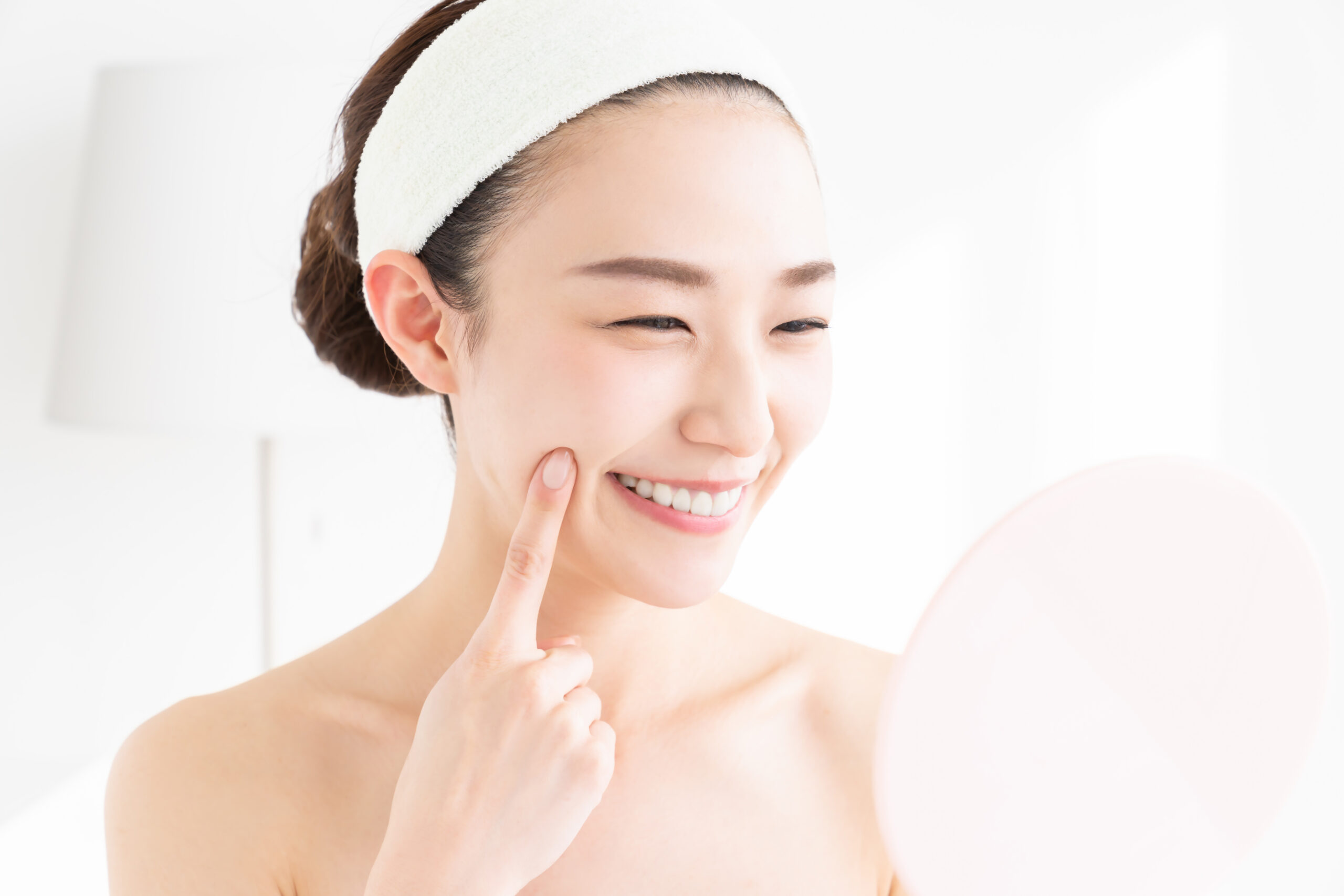 肌の調子を見てほほ笑む女性
